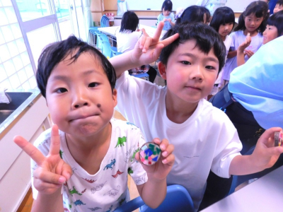 完成したバッジを見せる男の子たち