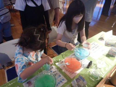 緑色、橙色、水色の芳香剤を用いて自分だけの芳香剤を作成している様子