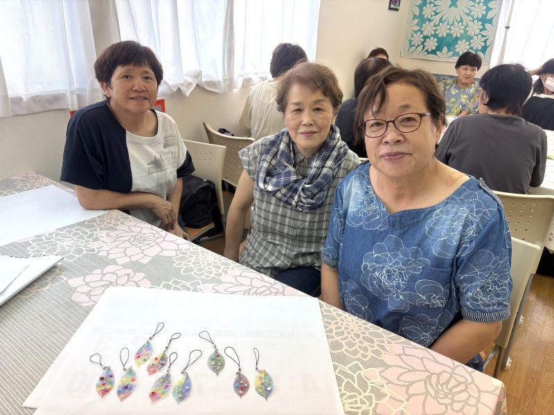 完成したチャームと参加者の笑顔の写真