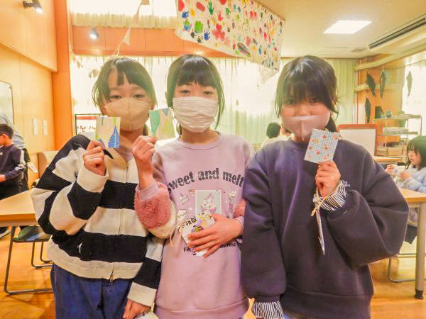 完成した豆本を手に持った子どもたちの写真