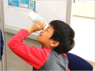 作成した万華鏡をのぞいている少年の様子