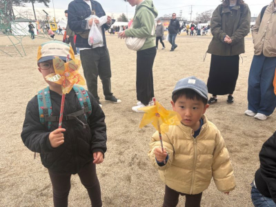 さくら型の風車を持つ子どもの写真