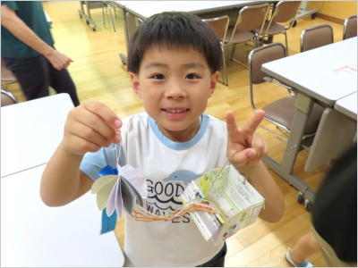 完成したクラゲのオーナメントを、笑顔で見せてくれる男の子の様子