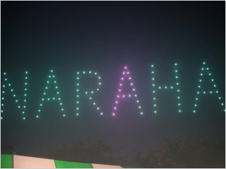 夜空に緑とピンクので大きく描かれた「NARAHA」の文字の写真