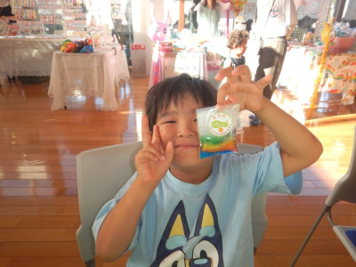 完成した作品を掲げ、笑顔でピースサインをしている男の子の写真