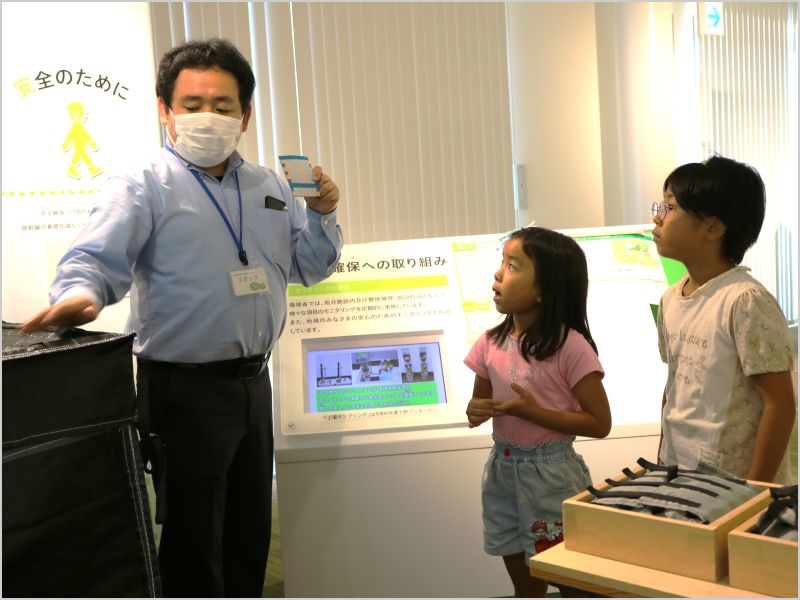 展示パネルの前で、子どもたちに説明をしている職員の様子