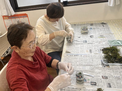 小さな飾りを入れて作品を装飾している様子