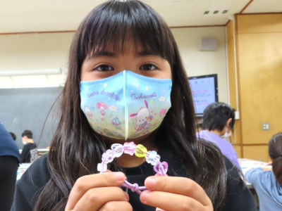 女の子が完成したアクセサリーをカメラに見せている写真