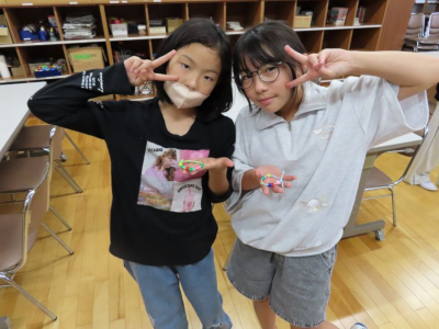 二人の女の子が完成したアクセサリーを持ちピースサインしている写真