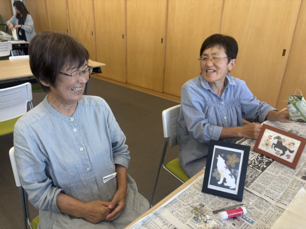 完成した完成したフォトアートを眺めて談笑する参加者の様子