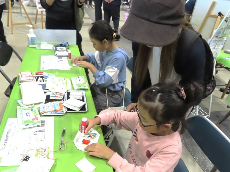 アップサイクルメモ帳を工作している子供と親御さん